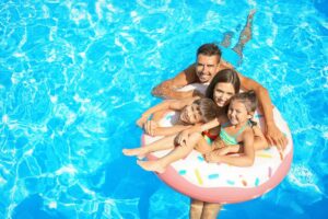 Family swimming together in a pool, highlighting concerns about lice survival in chlorinated water